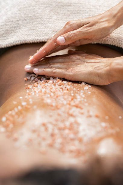 Hands massaging salt scrub on bare back