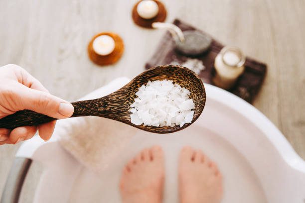 Wooden spoon with bath salts over foot soak