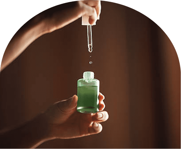 Hand holding green serum bottle with dropper